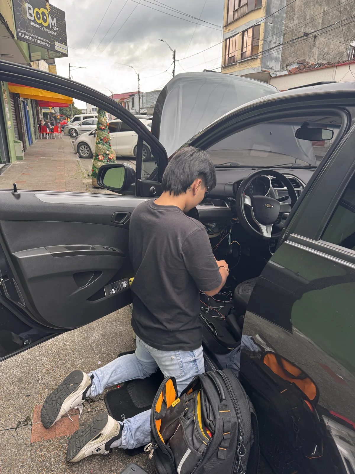Tecnico de BOOM GPS instalando un equipo GPS bajo el tablero de un vehiculo